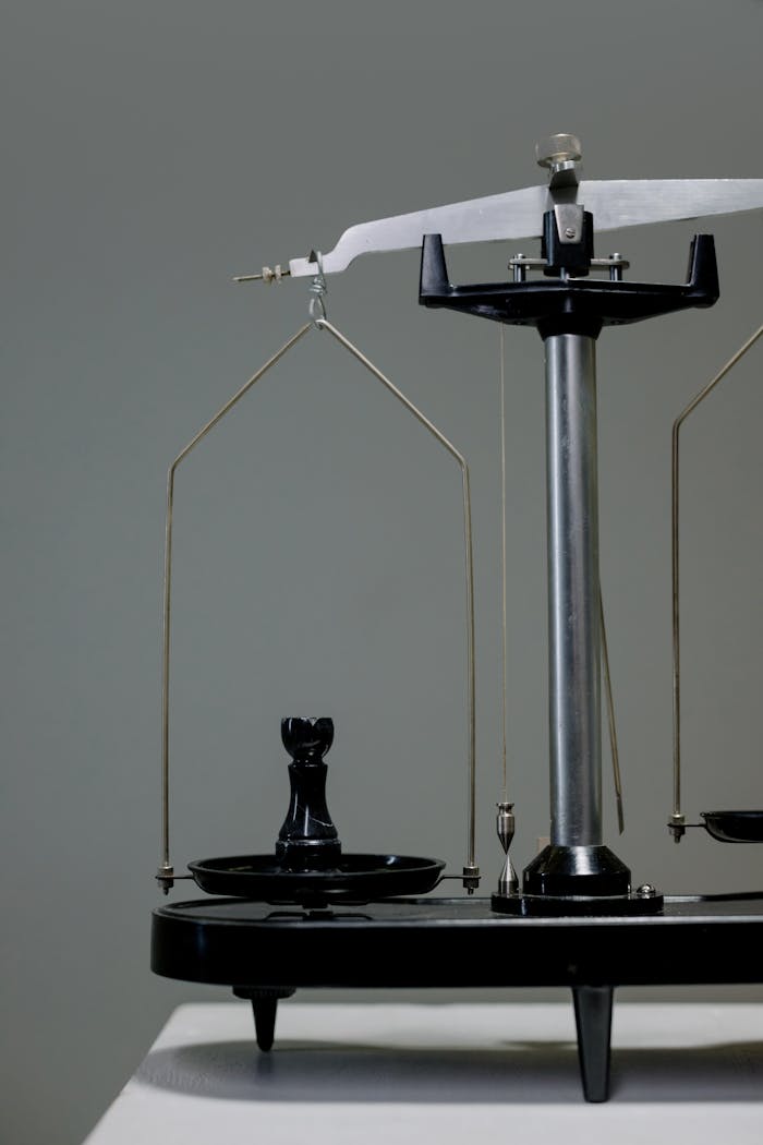 Close-up of a vintage scale with a chess piece balancing conceptually.